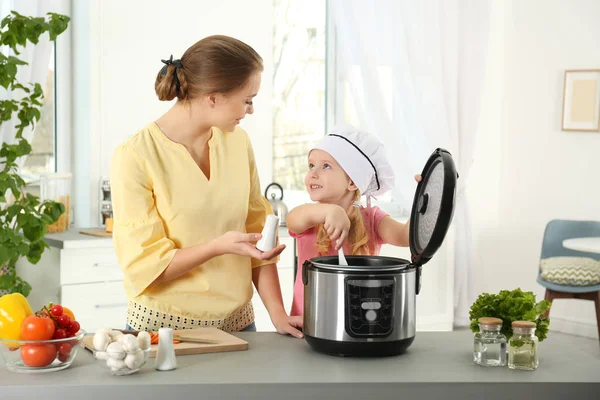 母亲和女儿准备食物与现代多炊具在厨房 — 图库照片