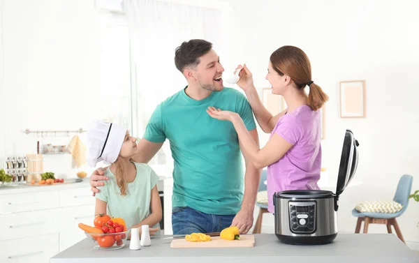 Família feliz preparando comida com fogão multi moderno na cozinha — Fotografia de Stock