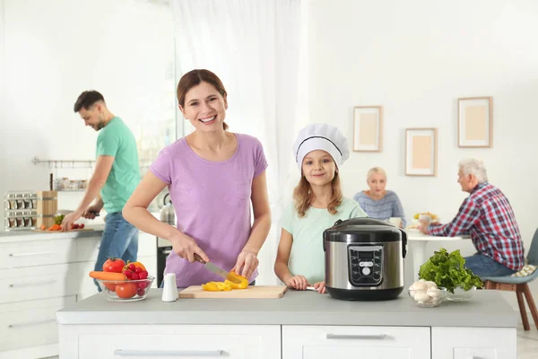 Familia feliz preparando la comida con cocina multi moderna en la cocina — Foto de Stock