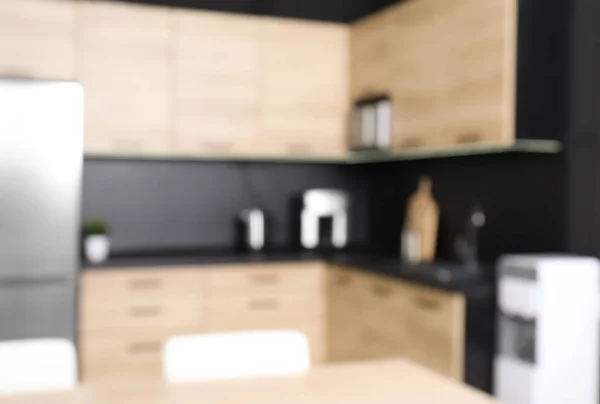 Blurred view of cozy modern kitchen interior with new furniture and appliances