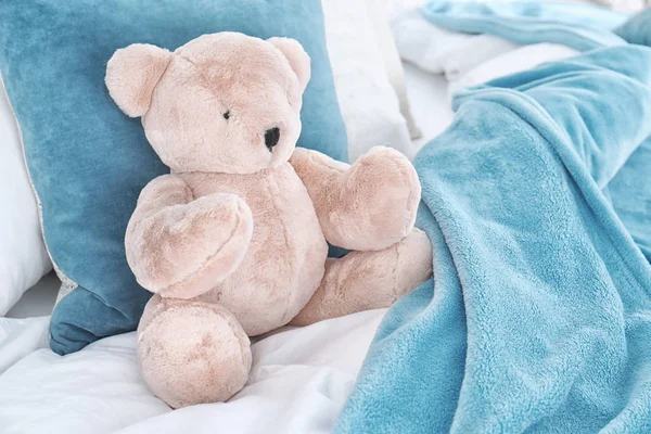 Niedlicher Teddybär sitzt drinnen im Bett. Raum für Text — Stockfoto