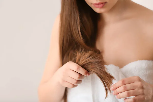 Mujer con el pelo dañado sobre fondo claro, primer plano. Puntas partidas — Foto de Stock