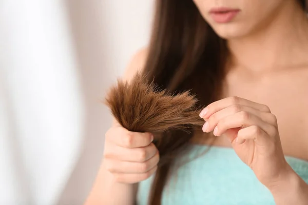 Donna con i capelli danneggiati su sfondo sfocato, primo piano. Dividi estremità — Foto Stock