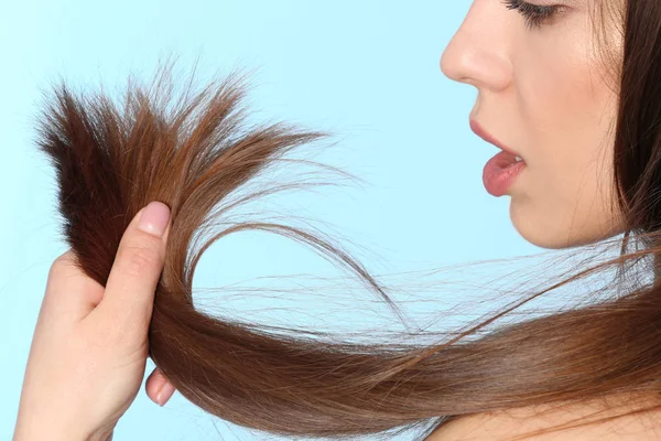 Mujer con el pelo dañado en el fondo de color, primer plano. Puntas partidas — Foto de Stock