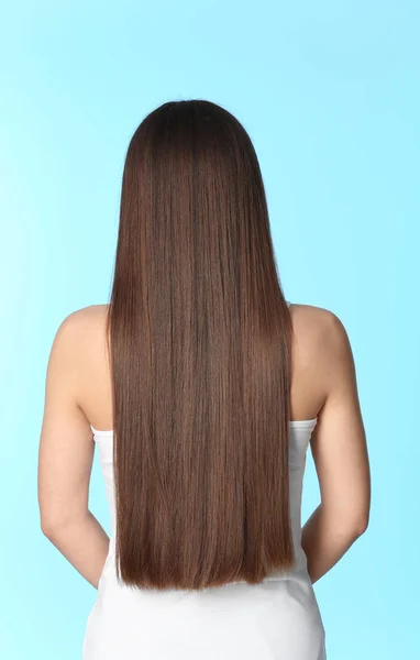 Mujer con cabello castaño largo sobre fondo de color — Foto de Stock
