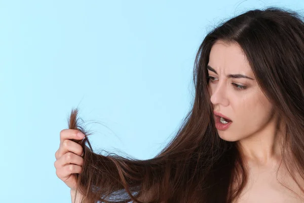 Mujer emocional con cabello dañado y espacio para texto sobre fondo de color. Puntas partidas — Foto de Stock