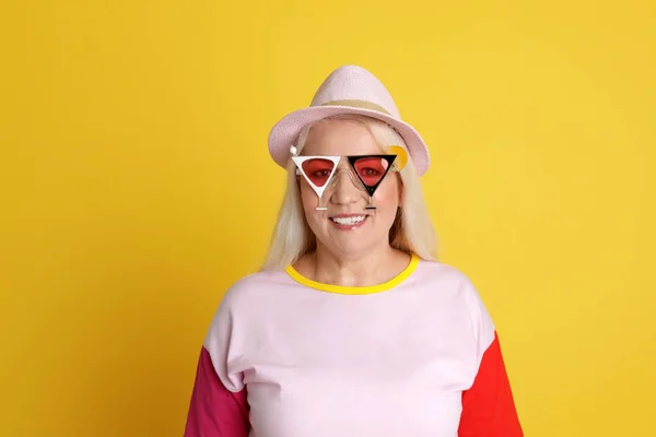 Портрет зрелой женщины в хипстерском костюме на цветном фоне — стоковое фото