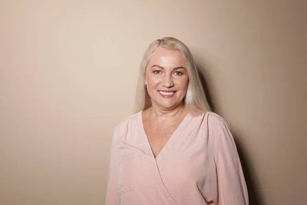 Portret van volwassen vrouw op kleur achtergrond — Stockfoto