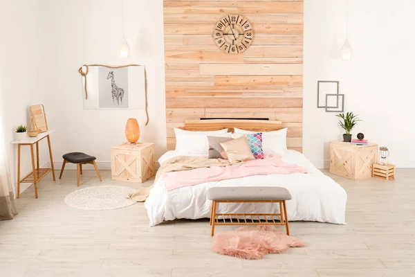 木製の壁の近くに快適なベッドとスタイリッシュな客室インテリア — ストック写真