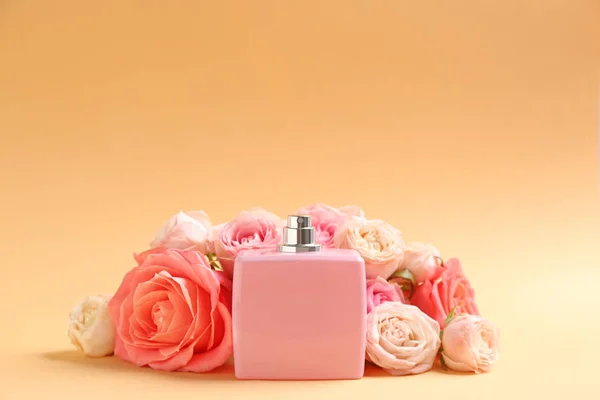 Fles parfum met mooie rozen op kleur achtergrond — Stockfoto