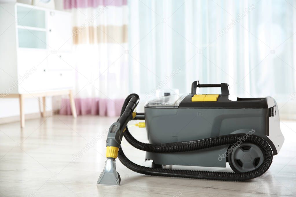 Wet and dry vacuum cleaner on floor indoors. Space for text
