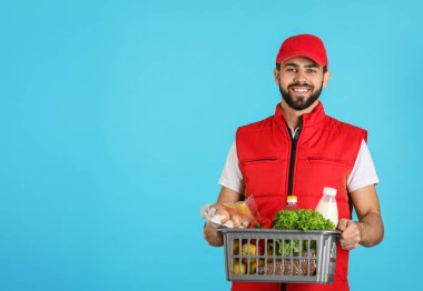 Renk arka plan, metin için yer üzerinde taze ürünlerle sepeti tutan adam. Gıda dağıtım hizmeti