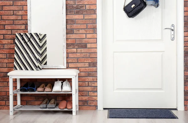 Інтер'єр коридору з вішалкою для взуття, дзеркалом і килимом біля дверей — стокове фото