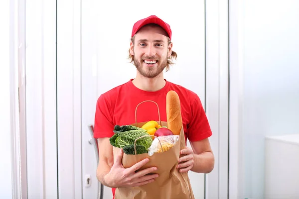 Livraison homme tenant sac en papier avec des produits alimentaires à l'intérieur — Photo