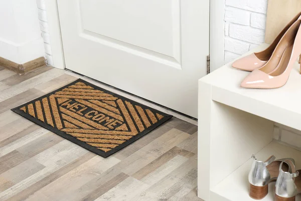 Shoe rack and mat near door in hallway — Stock Photo, Image