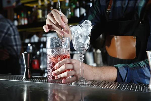 Barman mezcla de cóctel alcohólico en el mostrador en el club nocturno, primer plano —  Fotos de Stock