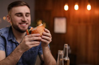 Genç adam kafede lezzetli hamburger yeme