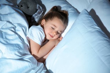 Güzel küçük kız yatakta oyuncakla gece uyku. Yatmadan zamanlama