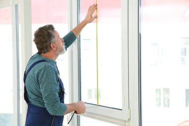 içerideki kurulum için pencereyi ölçen servis elemanı