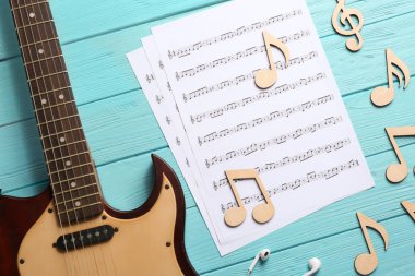Gitar boyun ve renk ahşap arka plan müzik notlar sayfalarıyla, düz yatıyordu