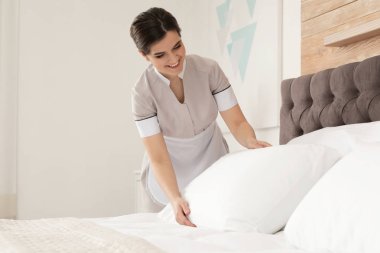 Genç hizmetçi otel odasında yatak yapma