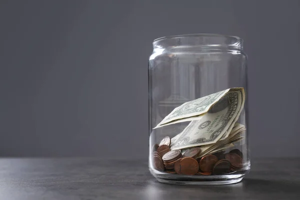 Pot de don avec de l'argent sur la table sur fond gris. Espace pour le texte — Photo