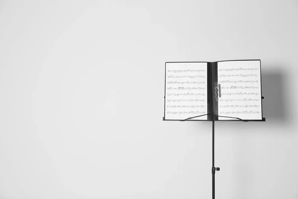 Support à notes avec feuilles de musique sur fond blanc. Espace pour le texte — Photo