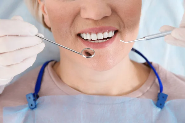 Dentiste examinant les dents du patient dans une clinique moderne, gros plan — Photo