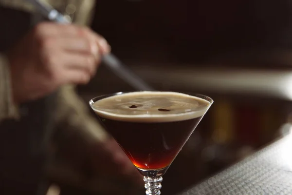 Sklenice espresso martini koktejl a rozmazané barman na pozadí, closeup — Stock fotografie