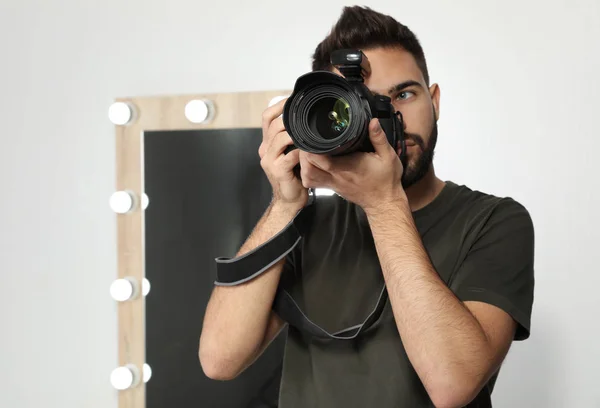 Jovem com câmera profissional no estúdio de fotografia. Espaço para texto — Fotografia de Stock