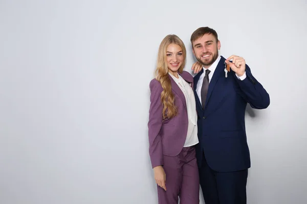Boldog fiatal üzletemberek ház kulcsát a világos háttér, a szöveg tér — Stock Fotó