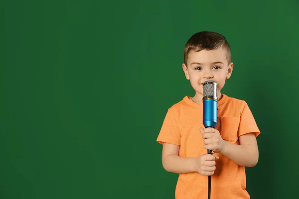 Söt rolig pojke med mikrofon på färgbakgrund. Utrymme för text — Stockfoto
