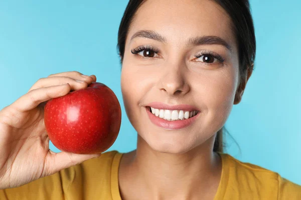 Mujer joven con dientes sanos y manzana sobre fondo de color, primer plano — Foto de Stock