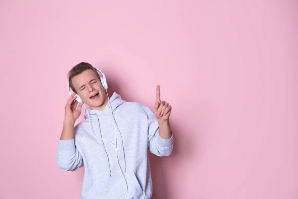 Niño adolescente escuchando música con auriculares en el fondo de color, espacio para el texto —  Fotos de Stock