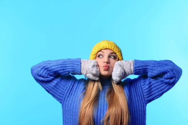 Portrait of emotional young woman in stylish hat, sweater and mittens on color background. Winter atmosphere — Stock Photo, Image