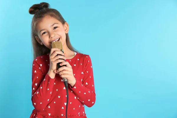 Χαριτωμένο αστείο κορίτσι με μικρόφωνο στο χρώμα φόντου. Χώρο για το κείμενο — Φωτογραφία Αρχείου