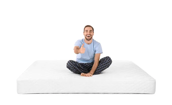 Jongeman zit op matras tegen witte achtergrond — Stockfoto