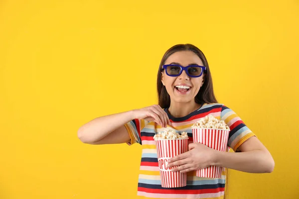 Mujer joven con gafas 3D y palomitas de maíz sabrosas sobre fondo de color — Foto de Stock