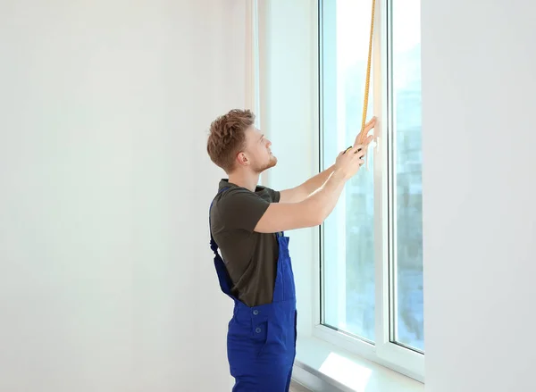 Service man measuring window for installation indoors. Space for text — Stock Photo, Image