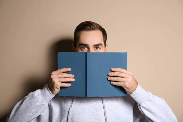 Joven leyendo libro cerca de la ventana en casa — Foto de Stock