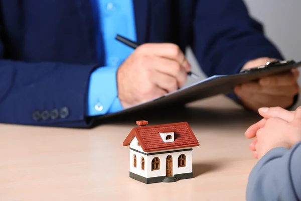 Immobilienmakler, der mit dem Kunden am Tisch im Büro arbeitet, Nahaufnahme. Wohngebäudeversicherung — Stockfoto
