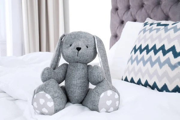 Милий іграшковий кролик сидить на ліжку в приміщенні — стокове фото