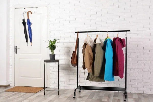 Stylish hallway interior with clothes on hanger stand