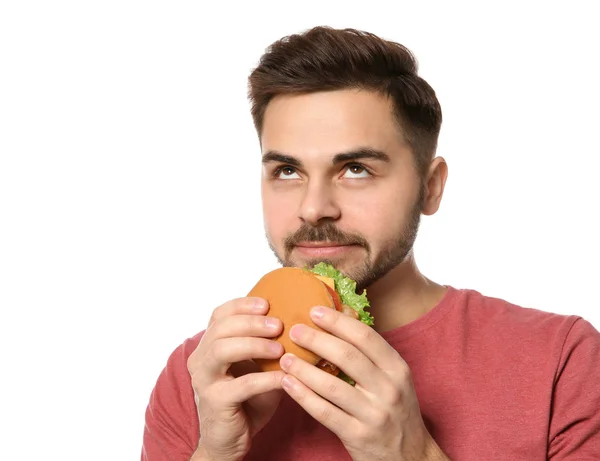 Handsome man eating tasty burger isolated on white — Stock Photo, Image