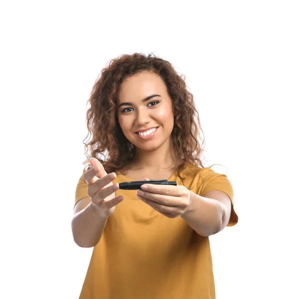 Mladí afroameričanka pomocí lancety pera na bílém pozadí. Kompenzace diabetu — Stock fotografie