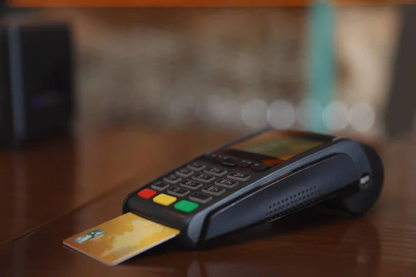 Credit card machine for non cash payment on wooden counter in cafe