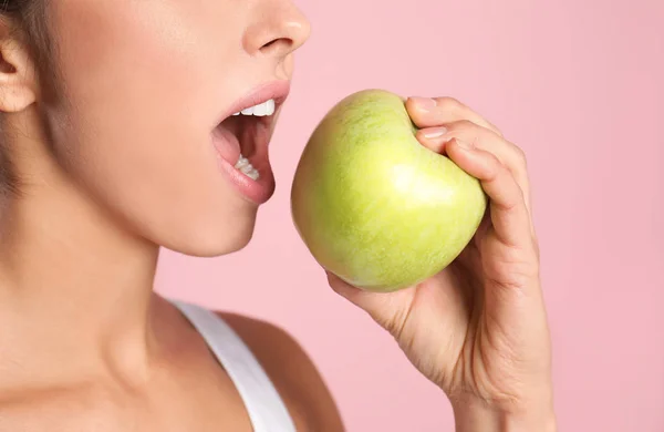 Mujer joven con dientes sanos y manzana sobre fondo de color, primer plano — Foto de Stock