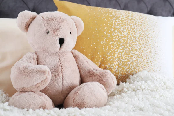 Niedlicher Teddybär sitzt drinnen im Bett. Raum für Text — Stockfoto