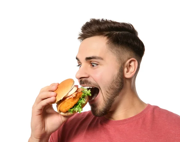 Bonito homem comendo hambúrguer saboroso isolado em branco — Fotografia de Stock