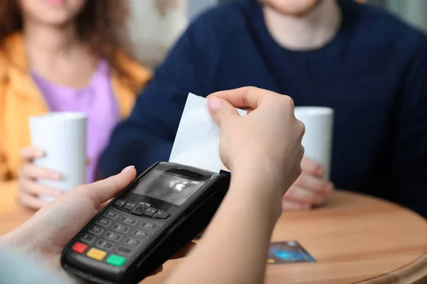 Clients gebruiken creditcard machine voor niet-contantbetaling in café, close-up — Stockfoto